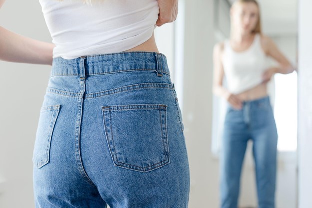 woman checking her new jeans in the mirror